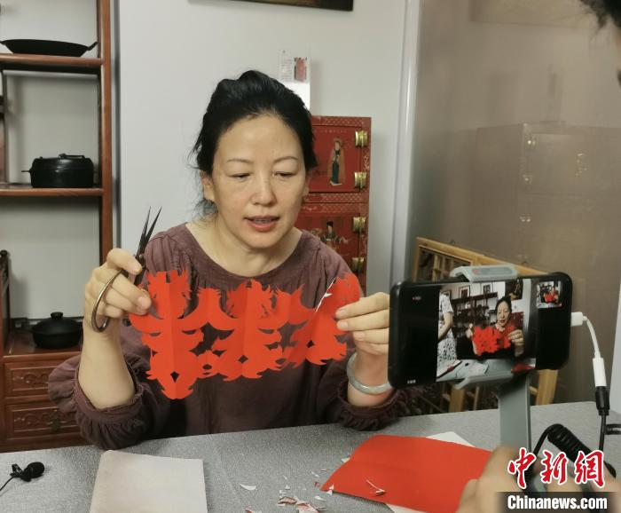 山西省民间剪纸艺术家协会会长郭梅花正在认真地教着海外华裔青少年剪纸。 杨杰英 摄 山西省民间剪纸艺术家协会会长郭梅花正在认真地教着海外华裔青少年剪纸。 杨杰英 摄