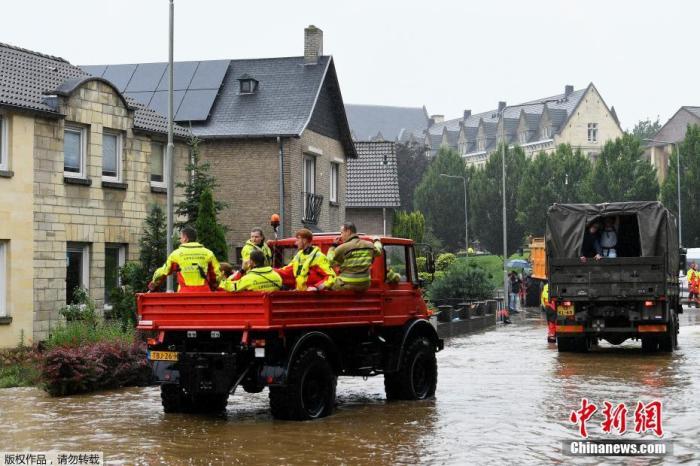 当地时间7月15日,在荷兰法肯堡发生大雨后,救生员乘坐救援车辆路过被洪水冲刷的道路。 点击进入下一页