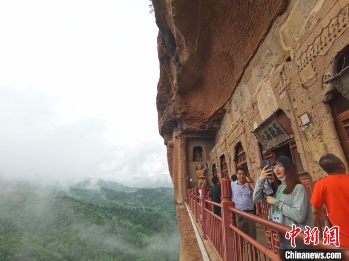 图为游人拍摄麦积山石窟风景区“仙境”。 张婧 摄 图为游人拍摄麦积山石窟风景区“仙境”。 张婧 摄