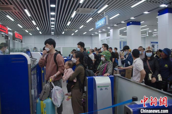 图为旅客在东兴口岸出境人员通道办理手续。 翟李强 摄 图为旅客在东兴口岸出境人员通道办理手续。 翟李强 摄