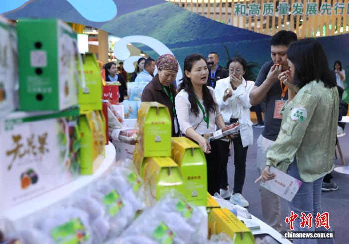 中国侨网9月25日，第二十三届中国绿色食品博览会与第十六届中国国际有机食品博览会在银川国际会展中心同步拉开帷幕。本届博览会以“绿色食品 提振消费”为主题，围绕“展示成果、促进贸易、推动发展”的办展宗旨，全面展现中国绿色食品和有机农产品产业发展的新进展与新成效。图为采购商在博览会现场品尝食品。中新社记者 于晶 摄